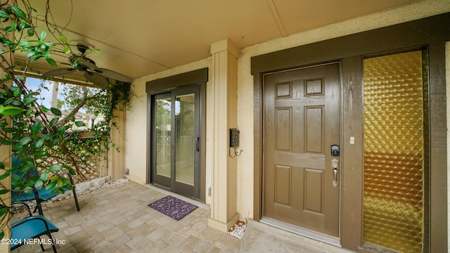 view of exterior entry featuring ceiling fan