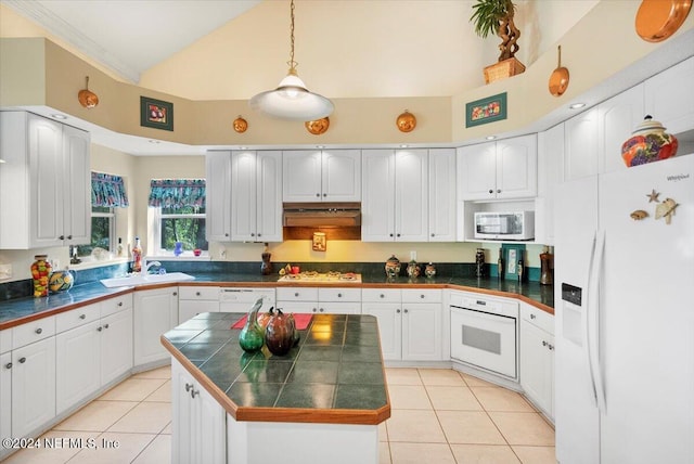 kitchen featuring a high ceiling, white appliances, white cabinetry, and light tile patterned floors