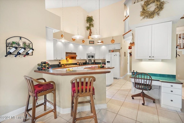 kitchen with kitchen peninsula, built in desk, white cabinetry, a high ceiling, and white refrigerator with ice dispenser