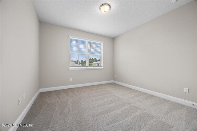 carpeted spare room with a textured ceiling