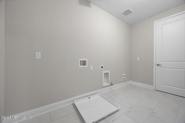 washroom with washer hookup, gas dryer hookup, a textured ceiling, and electric dryer hookup