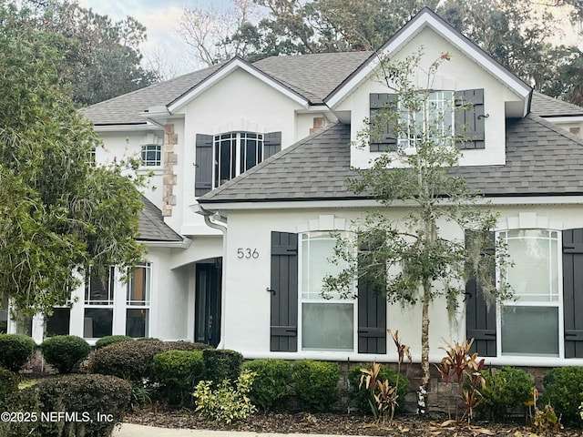 view of front of house with roof with shingles and stucco siding