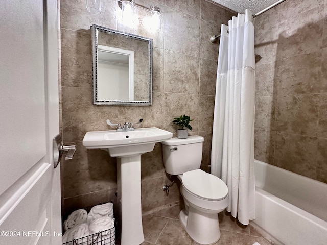 full bathroom with sink, tile patterned floors, toilet, shower / tub combo with curtain, and tile walls