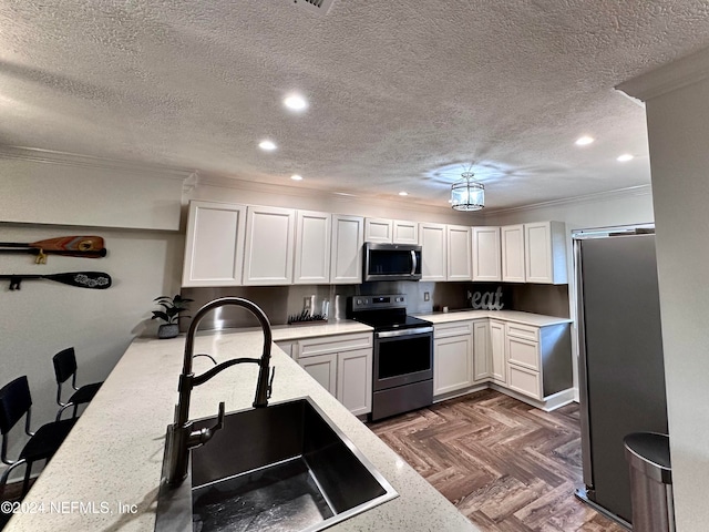 kitchen featuring appliances with stainless steel finishes, a textured ceiling, dark parquet floors, crown molding, and white cabinetry