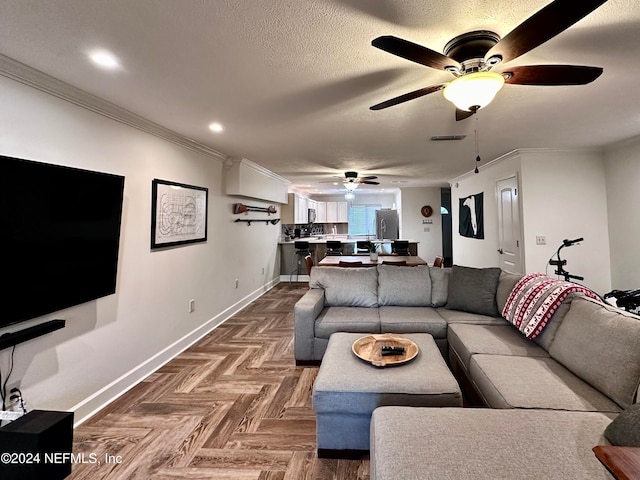 living room featuring a textured ceiling, parquet floors, ornamental molding, and ceiling fan