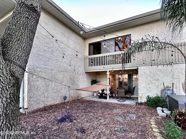 rear view of property featuring a balcony and a patio area