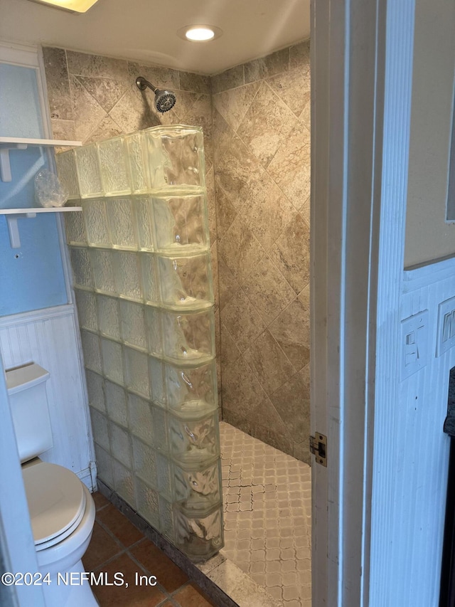 bathroom featuring a tile shower, toilet, and tile patterned floors