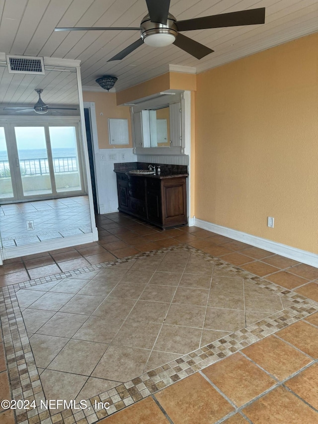 kitchen with wood ceiling, ornamental molding, sink, and tile patterned floors