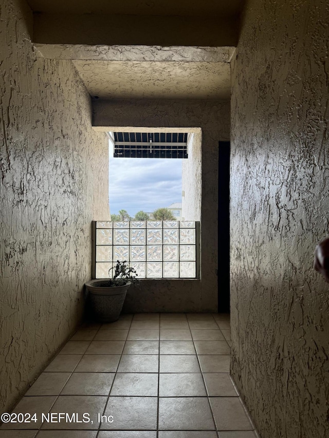 exterior space featuring beam ceiling and light tile patterned floors