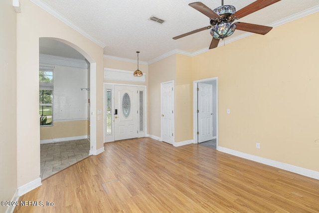 foyer entrance with ceiling fan, light hardwood / wood-style flooring, and crown molding