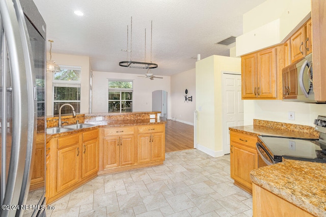 kitchen featuring pendant lighting, a textured ceiling, sink, stainless steel appliances, and ceiling fan