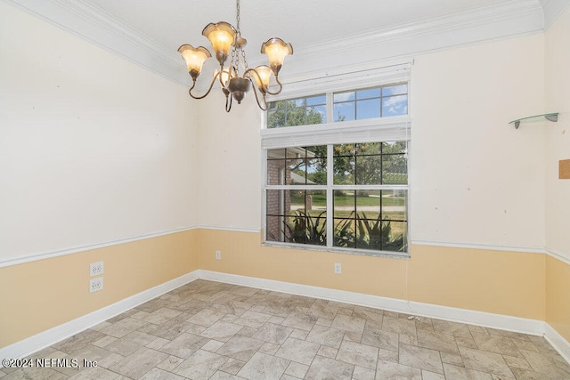 spare room featuring ornamental molding and a chandelier