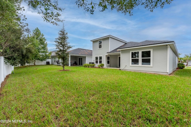 rear view of house featuring a lawn