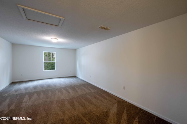 empty room with a textured ceiling and carpet flooring