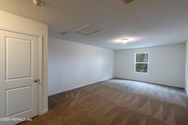 empty room with a textured ceiling and carpet flooring