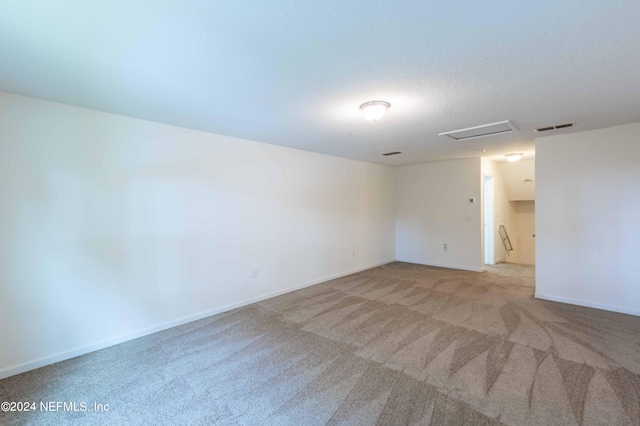 carpeted empty room with a textured ceiling