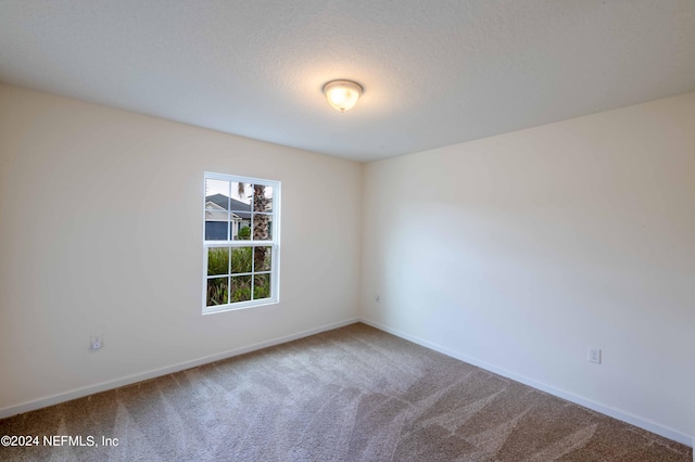 unfurnished room with a textured ceiling and carpet flooring