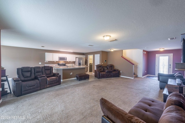 living room featuring a textured ceiling and light colored carpet