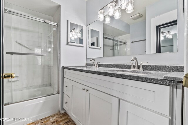 bathroom featuring wood-type flooring, vanity, and combined bath / shower with glass door