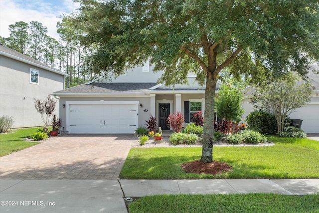 view of front of property featuring a front lawn and a garage