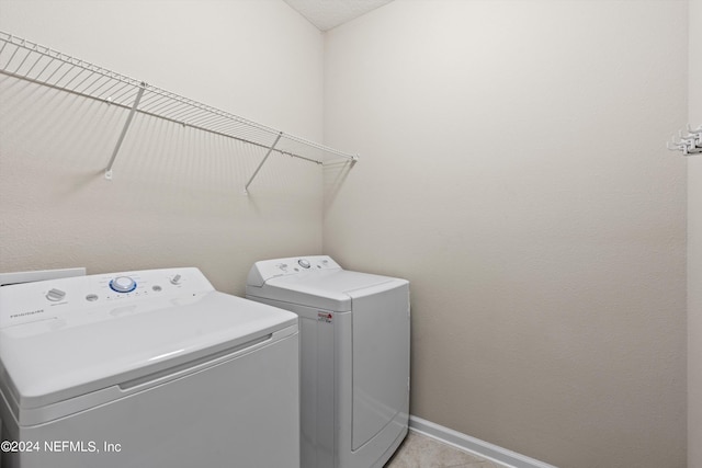 clothes washing area with separate washer and dryer and light tile patterned floors