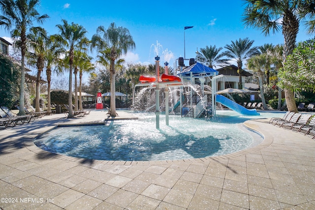 view of swimming pool with a water slide, pool water feature, and a playground