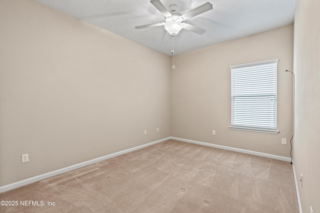 empty room featuring ceiling fan, light carpet, and a textured ceiling