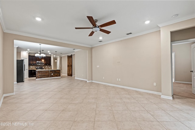 unfurnished living room with ornamental molding, light tile patterned flooring, a barn door, and ceiling fan with notable chandelier