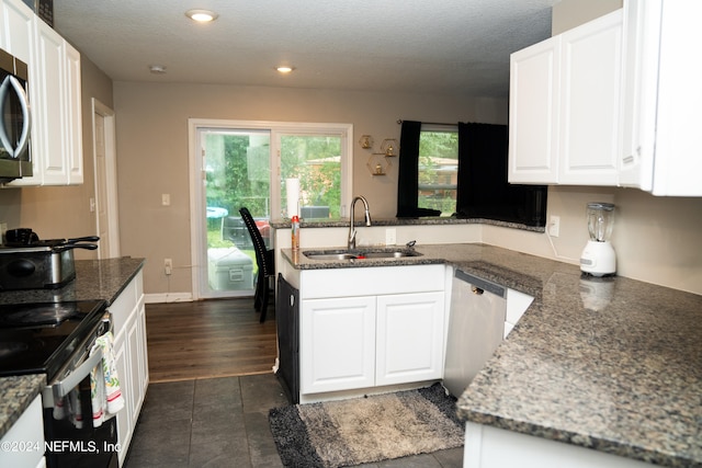 kitchen with stainless steel appliances, dark wood-type flooring, sink, and white cabinetry