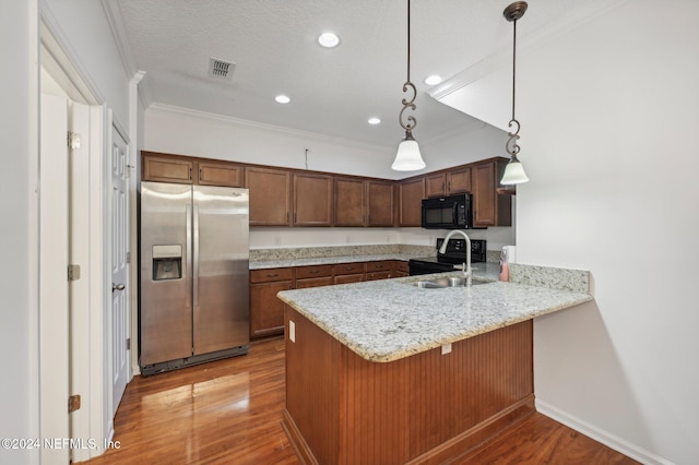 kitchen featuring pendant lighting, sink, kitchen peninsula, black appliances, and light hardwood / wood-style floors