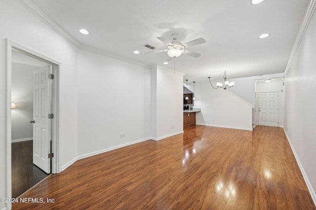 unfurnished living room featuring ceiling fan with notable chandelier, ornamental molding, and dark hardwood / wood-style flooring