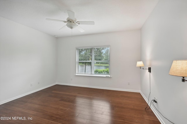 unfurnished room with ceiling fan and dark wood-type flooring