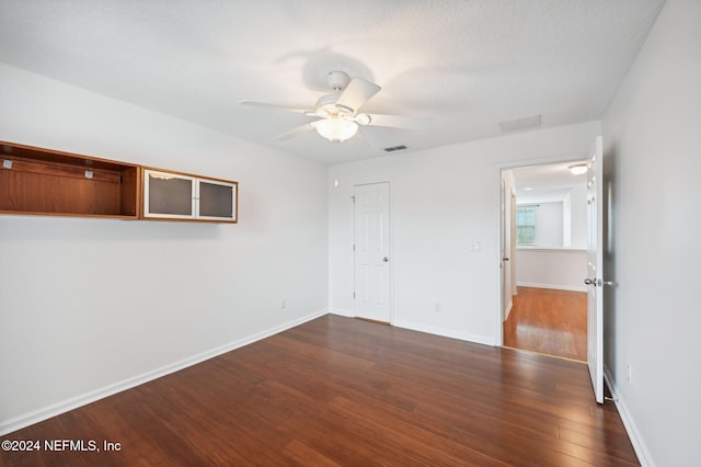 spare room featuring a textured ceiling, ceiling fan, and dark hardwood / wood-style flooring