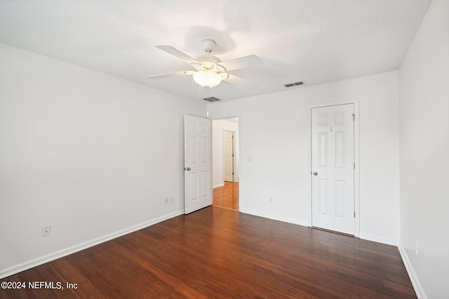 unfurnished bedroom featuring ceiling fan, dark hardwood / wood-style floors, and a textured ceiling