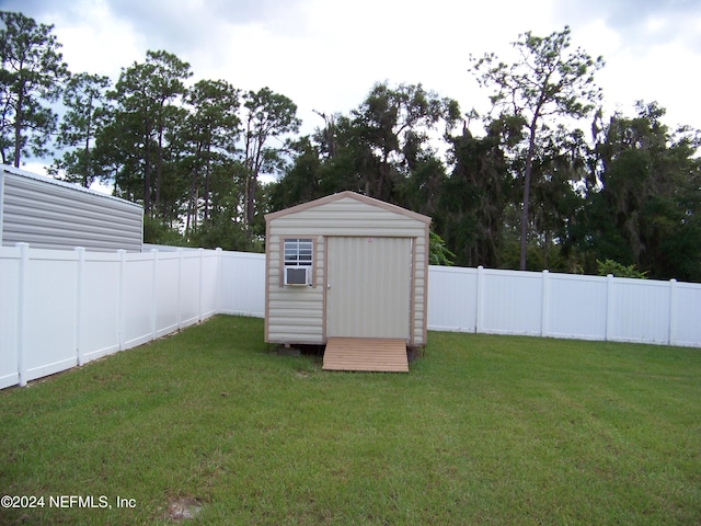 view of outbuilding with cooling unit and a yard