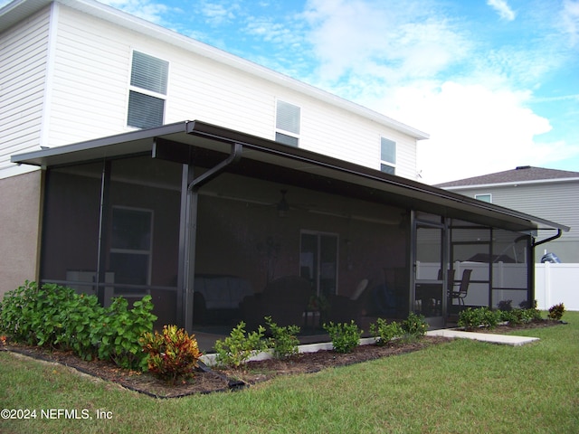 rear view of house with a sunroom and a lawn