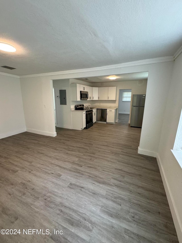 unfurnished living room with hardwood / wood-style flooring, crown molding, electric panel, and a textured ceiling