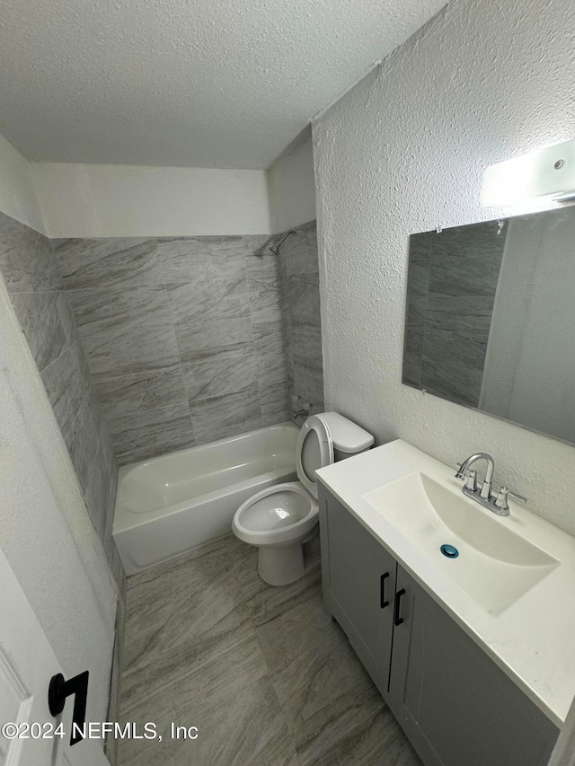 full bathroom featuring vanity, a textured ceiling, toilet, and tiled shower / bath combo