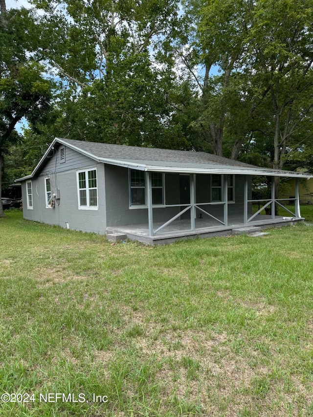 rear view of house featuring a yard