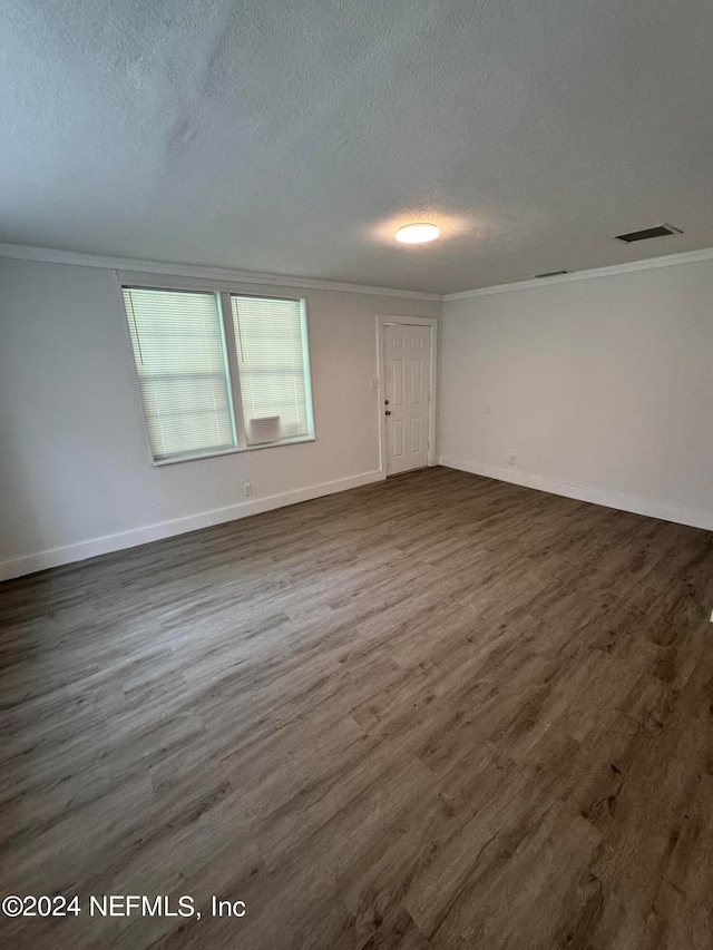 unfurnished room featuring a textured ceiling, dark hardwood / wood-style floors, and ornamental molding