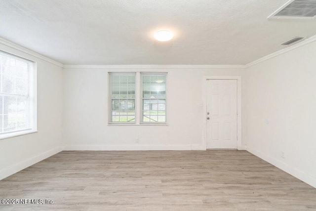 unfurnished room featuring light hardwood / wood-style flooring, crown molding, and a healthy amount of sunlight