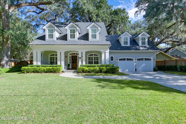 cape cod-style house featuring a garage, a front yard, and covered porch