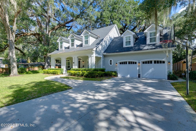 cape cod-style house with a front yard, a garage, and a porch