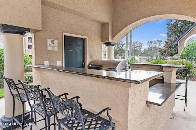 view of patio / terrace with an outdoor kitchen, a grill, and exterior bar