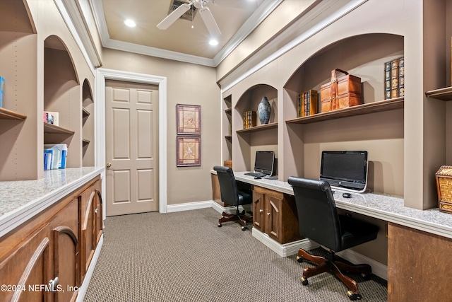 carpeted office with ceiling fan, built in features, built in desk, and ornamental molding