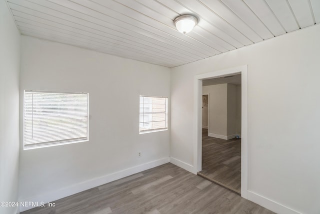 empty room featuring hardwood / wood-style floors and wooden ceiling