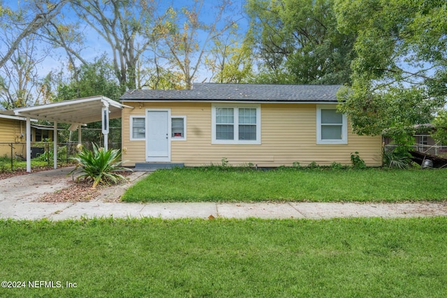 view of front of property with a front lawn and a carport