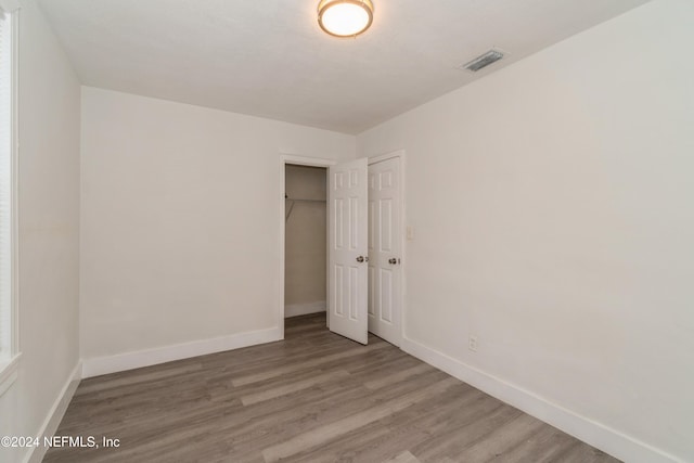 unfurnished bedroom with a closet and hardwood / wood-style floors