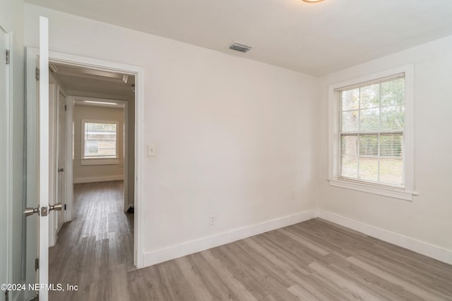 spare room with plenty of natural light and wood-type flooring