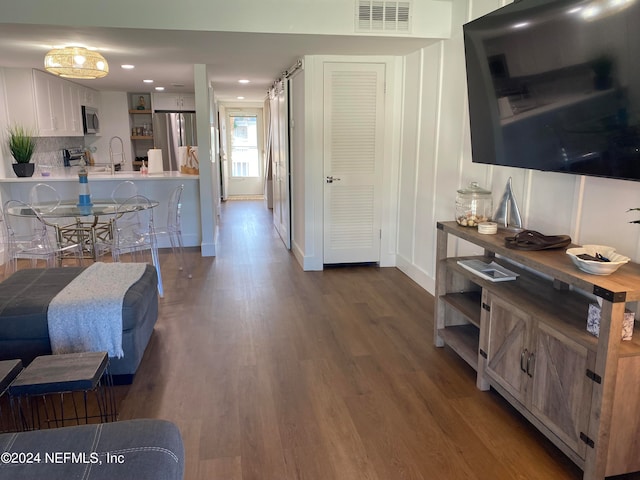 living room with dark hardwood / wood-style flooring and sink